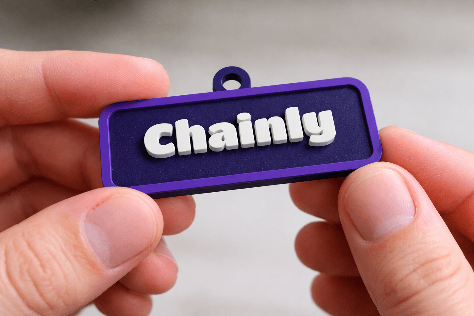 Output photo of a printed name tag keychain that reads 'CHAINLY'